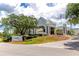 View of the East Lake Woodlands clubhouse featuring lush landscaping and a classic architectural style at 129 Lakeview Way, Oldsmar, FL 34677