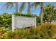 Community sign for Country Club Condominiums, nestled amidst lush greenery and colorful flowers at 129 Lakeview Way, Oldsmar, FL 34677