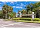 East Lake Woodlands entrance sign with manicured landscaping and blue skies at 129 Lakeview Way, Oldsmar, FL 34677