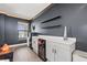 Bar area features modern cabinetry, mini-fridge, wine cooler, floating shelves, and recessed lighting for a welcoming space at 13102 Foxtail Fern Dr, Riverview, FL 33579