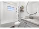 Bright bathroom featuring a tub-shower combination, decorative shelves, modern fixtures and a vanity sink at 13102 Foxtail Fern Dr, Riverview, FL 33579
