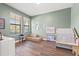 Spacious bedroom features two windows, hardwood floors, and playful decorations at 13102 Foxtail Fern Dr, Riverview, FL 33579