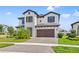 Two-story home with a two-car garage, and appealing landscaping, nestled in a sidewalk lined community at 13102 Foxtail Fern Dr, Riverview, FL 33579