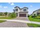 Inviting two-story home featuring a brick driveway, manicured lawn, and a two-car garage at 13102 Foxtail Fern Dr, Riverview, FL 33579