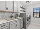 The laundry room features grey cabinets, lots of counter space and modern appliances at 13102 Foxtail Fern Dr, Riverview, FL 33579