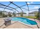 Screened-in pool with sun shelf, lounge seating, and built-in fire pit at 13102 Foxtail Fern Dr, Riverview, FL 33579