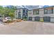 A two-story condo building featuring a gray color scheme, private garages, and lush landscaping at 13210 Arbor Isle Dr # 207, Temple Terrace, FL 33637