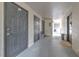 A condo hallway showcasing multiple doors, neutral tones, and natural light entering from the far end at 13210 Arbor Isle Dr # 207, Temple Terrace, FL 33637