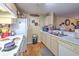 A bright kitchen with white appliances and light wood cabinets, offering ample counter space and storage at 13210 Arbor Isle Dr # 207, Temple Terrace, FL 33637