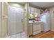 A compact kitchen featuring basic appliances and ample storage, next to the unit's entrance at 13210 Arbor Isle Dr # 207, Temple Terrace, FL 33637