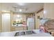 A cozy kitchen featuring basic appliances and storage, illuminated by modern track lighting at 13210 Arbor Isle Dr # 207, Temple Terrace, FL 33637