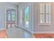 Bright foyer with decorative glass doors, tiled flooring, and views to adjoining rooms with hardwood floors at 1408 Brilliant Cut Way, Valrico, FL 33594