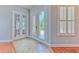 Bright foyer with decorative glass doors, tiled flooring, and views to adjoining rooms with hardwood floors at 1408 Brilliant Cut Way, Valrico, FL 33594