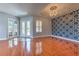 Bright living room featuring hardwood floors, statement wall, chandelier and glass paneled entry doors at 1408 Brilliant Cut Way, Valrico, FL 33594