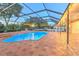 Inviting screened-in pool area with brick pavers, lights, and a charming fountain for outdoor relaxation and entertainment at 1408 Brilliant Cut Way, Valrico, FL 33594