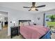 Comfortable bedroom features a ceiling fan, light blue walls, and a view of the property at 1657 Glengarry Dr, Palm Harbor, FL 34684