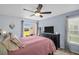 Relaxing bedroom boasts a ceiling fan, an exterior slider, and an abundance of natural light at 1657 Glengarry Dr, Palm Harbor, FL 34684