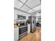 The modern kitchen features stainless steel appliances, white cabinets, and a view to the dining area at 1657 Glengarry Dr, Palm Harbor, FL 34684