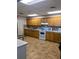 Well-equipped kitchen with abundant wooden cabinets and modern white appliances on a tile floor at 1657 Glengarry Dr, Palm Harbor, FL 34684