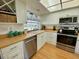 Bright kitchen featuring stainless steel appliances, a corner sink, and stylish, sea-turtle themed window treatment at 1657 Glengarry Dr, Palm Harbor, FL 34684