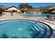 Beautiful community pool and hot tub area with deck chairs and well maintained landscaping at 1657 Glengarry Dr, Palm Harbor, FL 34684