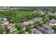 Expansive aerial view of a home nestled in a lush community with mature trees and a serene pond at 18243 Cypress Bay Pkwy, Land O Lakes, FL 34638