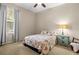 Cozy bedroom with a floral patterned bedspread, side table, and window with natural light at 18243 Cypress Bay Pkwy, Land O Lakes, FL 34638