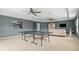 Large, carpeted game room with ping pong table, ceiling fans, and comfortable seating area at 18243 Cypress Bay Pkwy, Land O Lakes, FL 34638