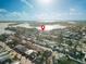 Aerial view of a three-story multifamily home with a black roof and white siding in a neighborhood near a body of water at 187 145Th E Ave # 3, Madeira Beach, FL 33708