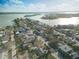 Aerial view of a neighborhood near a body of water with a three-story multifamily home with a black roof and white siding at 187 145Th E Ave # 3, Madeira Beach, FL 33708