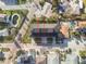 Top-down aerial view of a three-story multifamily home with a black roof, a small front yard, and street parking at 187 145Th E Ave # 3, Madeira Beach, FL 33708