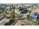 Aerial view of a three-story multifamily home with a black roof, white siding, and small front yards near other homes and the ocean at 187 145Th E Ave # 3, Madeira Beach, FL 33708