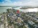 Aerial view of a neighborhood near a body of water with a three-story multifamily home with a black roof and white siding at 187 145Th E Ave # 3, Madeira Beach, FL 33708
