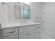 Bathroom with a white vanity, framed mirror, and view into the blue tile shower at 187 145Th E Ave # 3, Madeira Beach, FL 33708