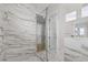 Luxury bathroom features include marble walls, frameless glass shower with bench, and bright lighting at 187 145Th E Ave # 3, Madeira Beach, FL 33708