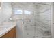 Bathroom boasts a glass shower, modern vanity with a white countertop, and marbled walls at 187 145Th E Ave # 3, Madeira Beach, FL 33708