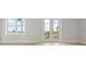 Large windows and french doors illuminate this bedroom with wood floors and neutral walls at 187 145Th E Ave # 3, Madeira Beach, FL 33708
