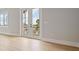 Bedroom with wood floors and bright view from double doors leading to the balcony at 187 145Th E Ave # 3, Madeira Beach, FL 33708