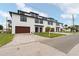 Modern townhouse exteriors with white siding, black trim, and brick driveways create curb appeal at 187 145Th E Ave # 3, Madeira Beach, FL 33708