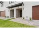 Exterior of townhome featuring stone entryway and wood-look garage doors at 187 145Th E Ave # 3, Madeira Beach, FL 33708