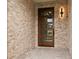Contemporary front door featuring multiple glass panes, set within a stone facade and enhanced by modern exterior lighting at 187 145Th E Ave # 3, Madeira Beach, FL 33708