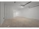 Spacious garage area features white-painted walls, a single ceiling light and concrete flooring at 187 145Th E Ave # 3, Madeira Beach, FL 33708
