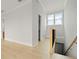 Hallway with wood floors leading to rooms and stairway, offering a bright and open space at 187 145Th E Ave # 3, Madeira Beach, FL 33708