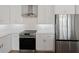 Well-lit kitchen with stainless steel appliances, white cabinets, and a modern vent hood at 187 145Th E Ave # 3, Madeira Beach, FL 33708