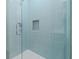 A modern glass enclosed shower featuring elegant blue tiling and shower niche at 187 145Th E Ave # 3, Madeira Beach, FL 33708