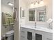 Modern bathroom with a white vanity, mirrored cabinets, and well-lit lighting at 19029 Us Highway 19 N # 26-204, Clearwater, FL 33764