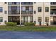 Exterior building view with balconies, well-maintained landscaping, and paved driveway at 19029 Us Highway 19 N # 26-204, Clearwater, FL 33764