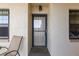 Inviting front door with sidelight windows and a chair outside providing a welcoming entrance to the property at 19029 Us Highway 19 N # 26-204, Clearwater, FL 33764