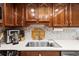 Kitchen features wood cabinets, stone backsplash, stainless steel appliances and updated fixtures at 19029 Us Highway 19 N # 26-204, Clearwater, FL 33764