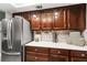 Well-maintained kitchen featuring wood cabinets, granite countertops, and stainless steel refrigerator at 19029 Us Highway 19 N # 26-204, Clearwater, FL 33764